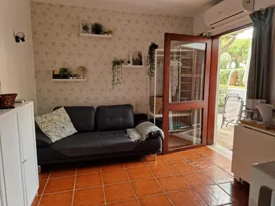 a living room with a couch and a glass door at Paulo's 104 in Albufeira