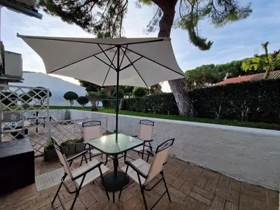 a table and chairs with an umbrella on a patio at Paulo's 104 in Albufeira