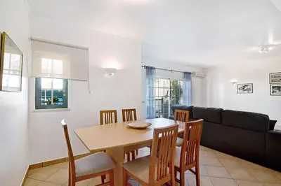 a dining room and living room with a table and chairs at Villa Catarina in Albufeira