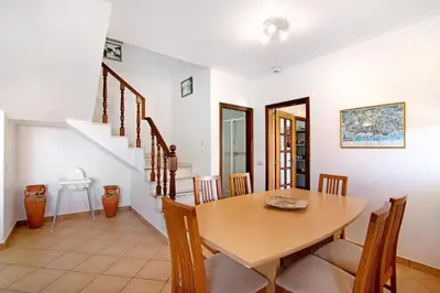 a dining room with a wooden table and chairs at Villa Catarina in Albufeira