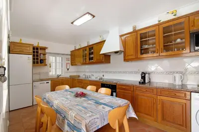 a kitchen with a table and a table and chairs at Villa Guisado in Albufeira