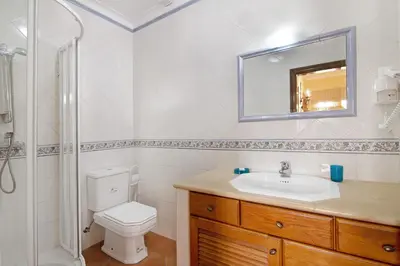 a bathroom with a toilet and a sink and a mirror at Villa Guisado in Albufeira