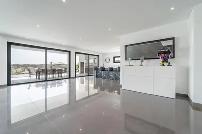 a living room with white walls and a large window at Villa das Amendoeiras by HelloVacations in Albufeira