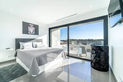 a bedroom with a bed and a large window at Villa das Amendoeiras by HelloVacations in Albufeira