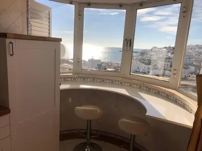 a bathroom with two stools in front of a window at Beachfront 2 bedroom apartment in Albufeira