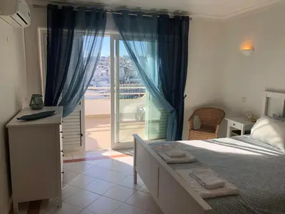 a bedroom with a bed and a dresser and a closet at Beachfront 2 bedroom apartment in Albufeira