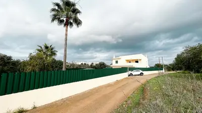 a white car parked next to a fence and a palm tree at Villa Pedro by Sunny Deluxe in Albufeira