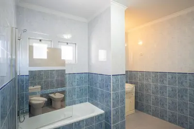 a blue tiled bathroom with a toilet and a sink at Apartment Claro Azul in Albufeira