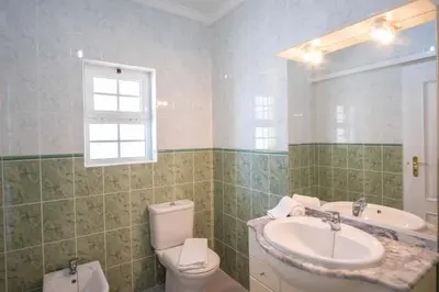 a bathroom with a sink and a toilet and a mirror at Apartment Claro Azul in Albufeira