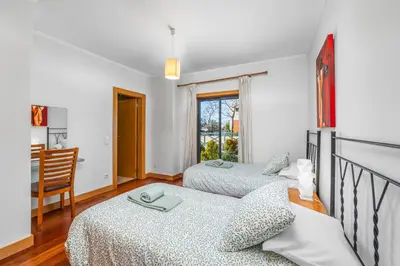 a bedroom with two beds and a dining room at Albufeira Corcovada Apartments in Albufeira