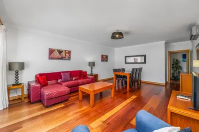 a living room with a red couch and a table at Albufeira Corcovada Apartments in Albufeira