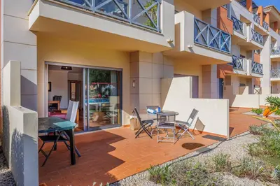 a patio with a table and chairs in front of a building at Albufeira Corcovada Apartments in Albufeira