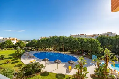 an overhead view of a swimming pool with umbrellas at Albufeira Corcovada Apartments in Albufeira