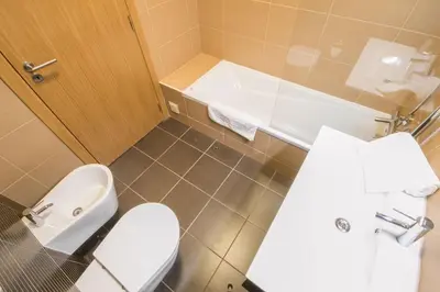 a bathroom with a toilet and a sink and a tub at Marina Jardim - Great complex for families in Albufeira