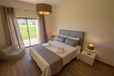 a bedroom with a large bed and a large window at Marina Jardim - Great complex for families in Albufeira