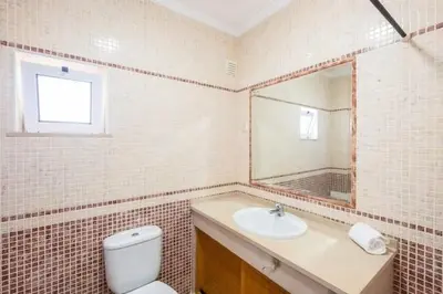 a bathroom with a toilet and a sink and a mirror at Apartment Alfarmar - pool, beach only a few minutes away in Albufeira
