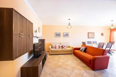 a living room with a couch and a tv at Apartment Alfarmar - pool, beach only a few minutes away in Albufeira