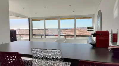 a dining room with a table and chairs and windows at Albufeira, Modern Sea View Home 33 in Albufeira