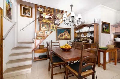 a dining room with a table and a staircase at T3 Duplex Albufeira in Olhos de Água