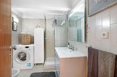 a bathroom with a washing machine and a washer at T3 Duplex Albufeira in Olhos de Água