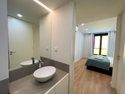 a bathroom with a toilet and a sink and a bed at Faro Design 5 by Homing in Faro