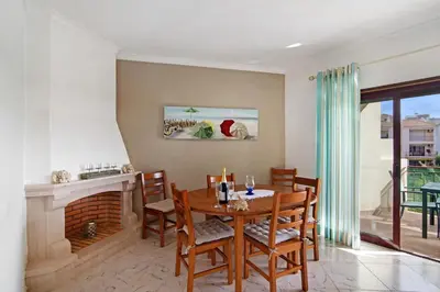 a dining room with a table and a fireplace at Columbus Beach Apartment in Quarteira