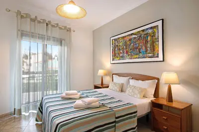 a bedroom with a large bed with two towels on it at Columbus Beach Apartment in Quarteira