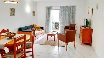 a living room with a couch and a table and chairs at Apartamento AnaMar by Sunnyway in Albufeira