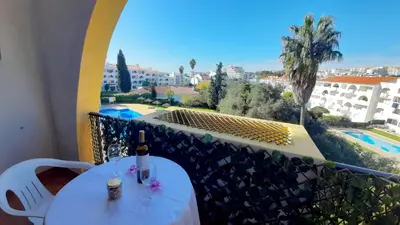 a table with a bottle of wine on a balcony at Apartamento AnaMar by Sunnyway in Albufeira