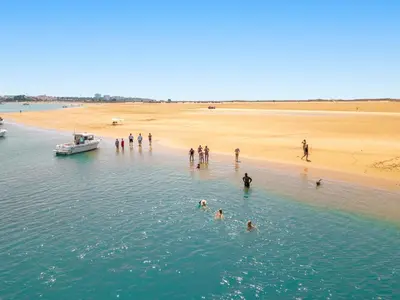 a group of people standing in the water near a beach at Apartment Montego Bay by Algarve Vacation in Albufeira