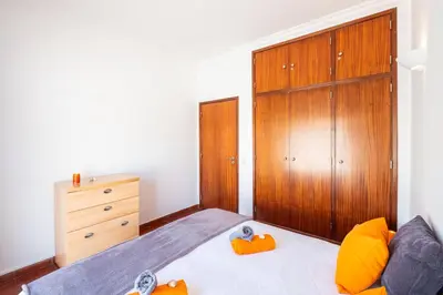 a bedroom with a bed and a wooden closet at Villa Bermudas by Algarve Vacation in Albufeira