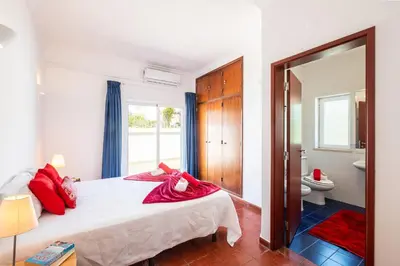 a bedroom with a bed with red pillows on it at Villa Bermudas by Algarve Vacation in Albufeira