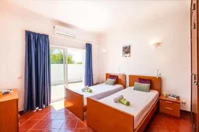 two beds in a room with a window at Villa Bermudas by Algarve Vacation in Albufeira