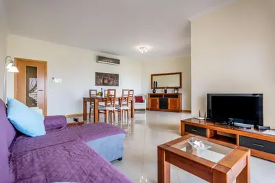 a living room with a purple couch and a tv at SeaViewSunset - Encosta da Orada in Albufeira