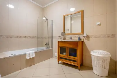 a bathroom with a tub and a sink and a mirror at SeaViewSunset - Encosta da Orada in Albufeira