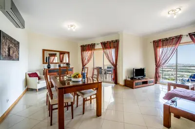 a living room with a table and chairs and a couch at SeaViewSunset - Encosta da Orada in Albufeira