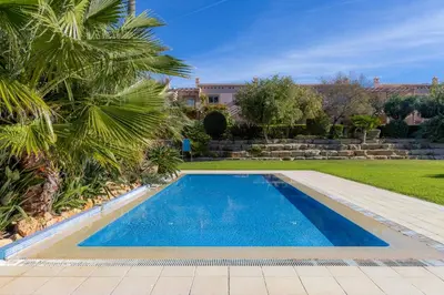 a swimming pool in a yard with palm trees at BALAIA RESIDENCE - Fantástica moradia para 6 com piscina e BBQ in Olhos de Água