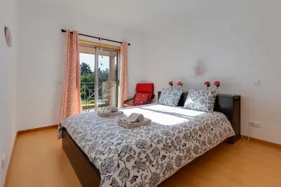 a bedroom with a bed and a window at BALAIA RESIDENCE - Fantástica moradia para 6 com piscina e BBQ in Olhos de Água