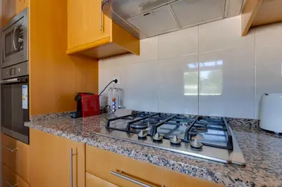a kitchen with a stove top in a kitchen at BALAIA RESIDENCE - Fantástica moradia para 6 com piscina e BBQ in Olhos de Água