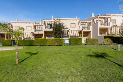 a large apartment building with a lawn in front of it at BALAIA RESIDENCE - Fantástica moradia para 6 com piscina e BBQ in Olhos de Água