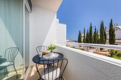a balcony with two chairs and a table on a balcony at Coração do Mar by OCvillas in Albufeira