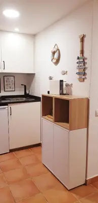 a kitchen with white cabinets and a tile floor at Estúdio na Falésia in Albufeira