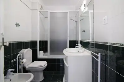 a white bathroom with a toilet and a sink at Apartamento Kaya by Sunnyway in Albufeira
