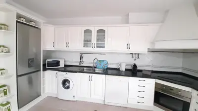 a white kitchen with a sink and a dishwasher at Apartamento Kaya by Sunnyway in Albufeira