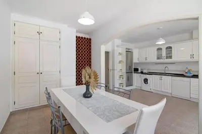 a dining room with a table and chairs and a kitchen at Apartamento Kaya by Sunnyway in Albufeira