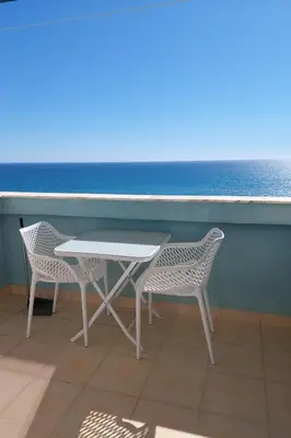 a table and two chairs sitting next to the ocean at Appartement vista Mar Quarteira in Quarteira