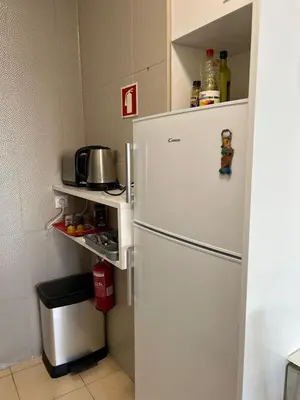 a white refrigerator in a kitchen with a shelf at Appartement vista Mar Quarteira in Quarteira