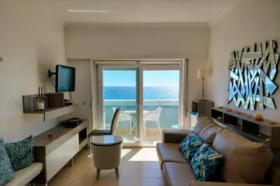 a living room with a couch and a view of the ocean at Appartement vista Mar Quarteira in Quarteira