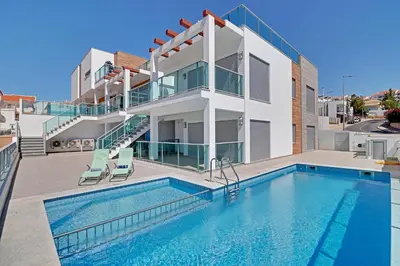 a house with a swimming pool in front of a house at Ocean Chic by the Beach in Albufeira
