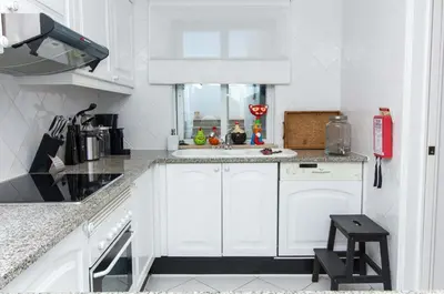 a white kitchen with white cabinets and a sink at Apartamento Luna - Golf View By Dalma Portuguesa in Albufeira